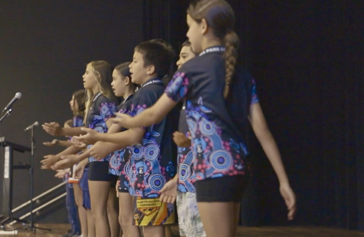 Aboriginal children singing and dancing on stage